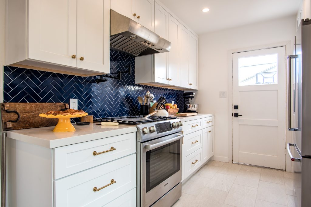 Modern pre fabricated white kitchen with blue harringbone backsplash in Encino Los Angeles